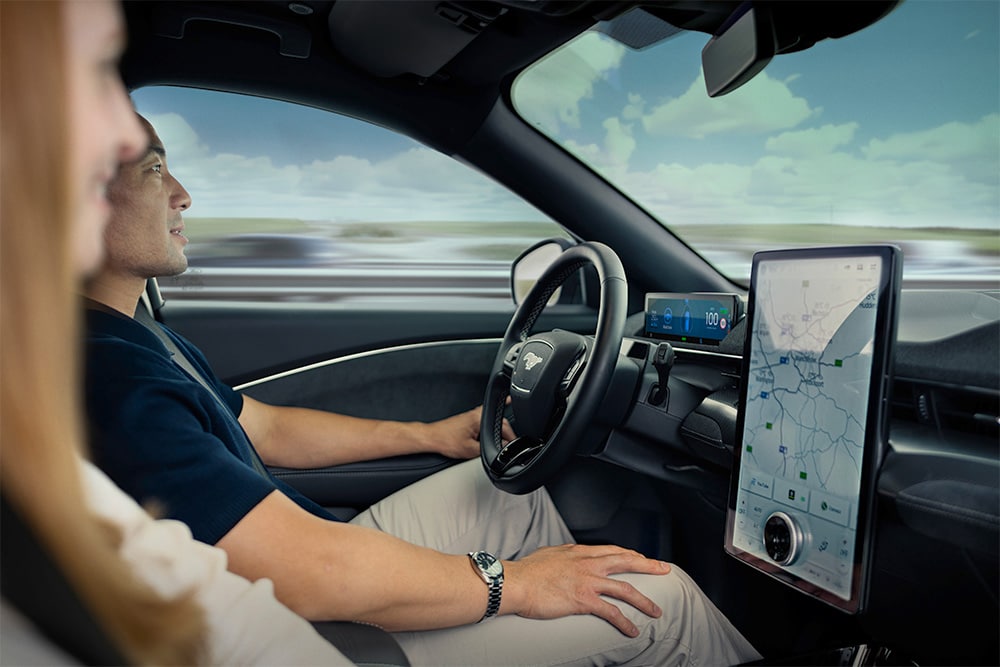 Nahaufnahme von Fahrer und Beifahrer im vorderen Bereich eines Mustang Mach-E.