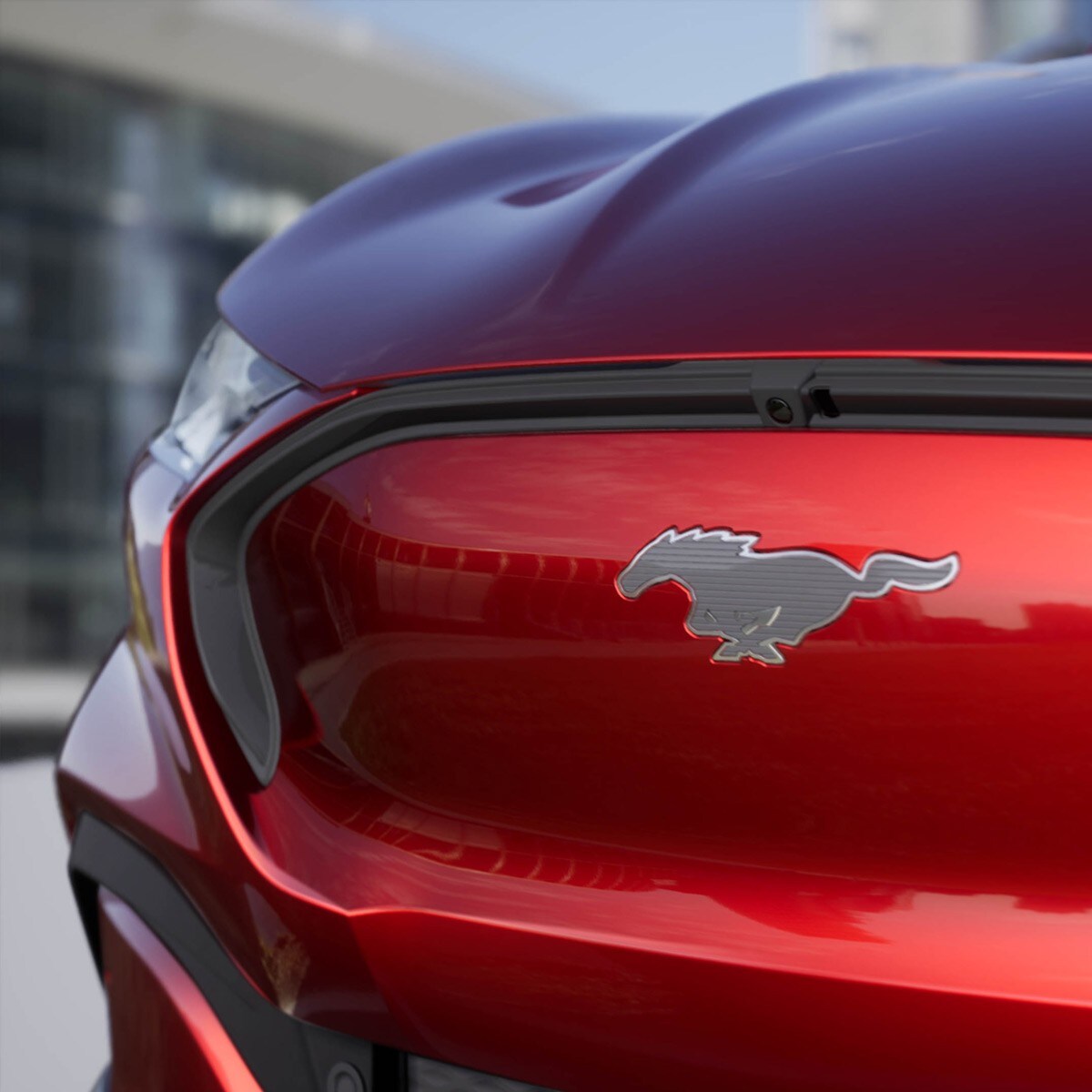 Ford Mustang Mach-E in rot. Detailansicht Front mit silbernem Mustang-Pony