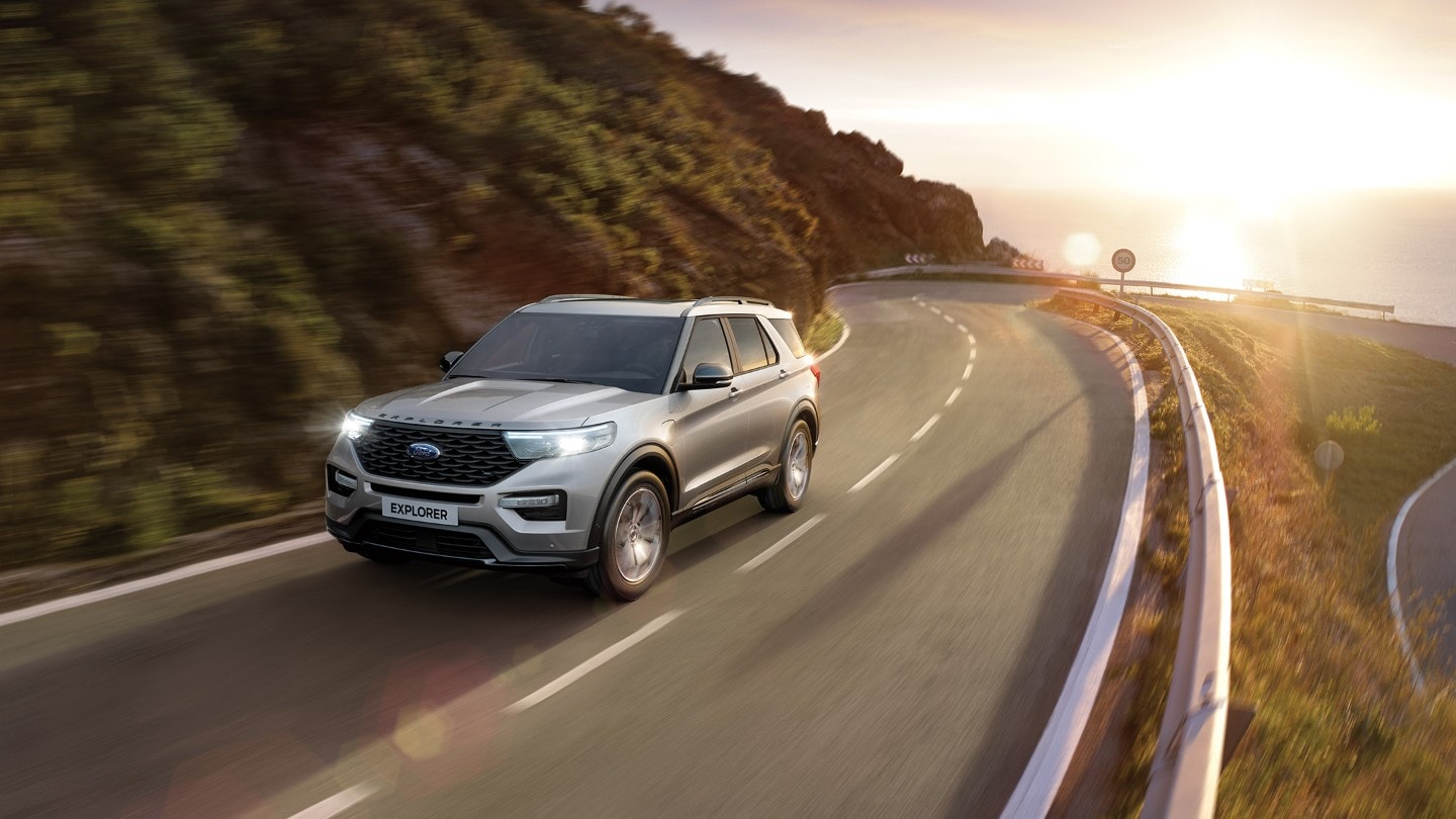 Ford Explorer Plug-in-Hybrid in Silber. Fahrszene auf einer kurvigen Landstraße