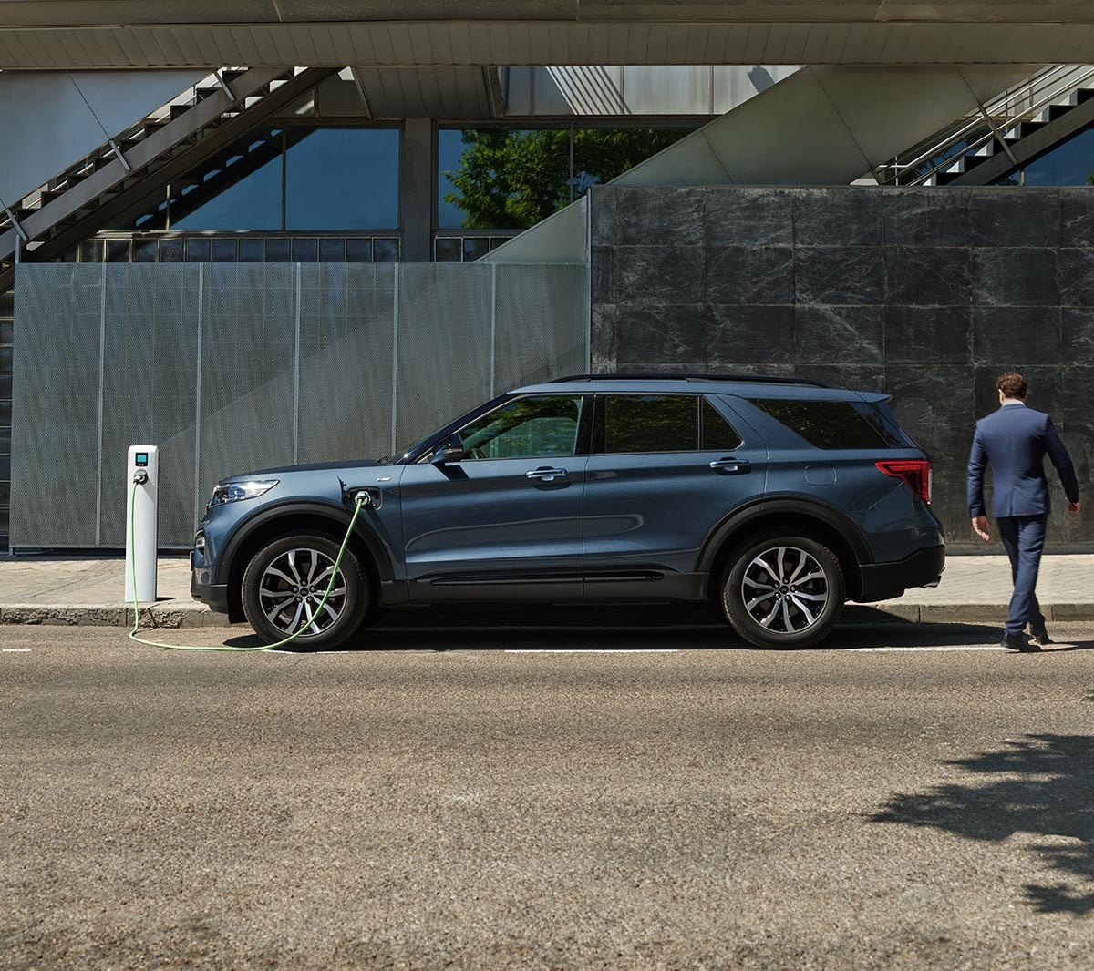 Ford Explorer Plug-in-Hybrid in Blau. Seitenansicht. An einer Ladestation parkend