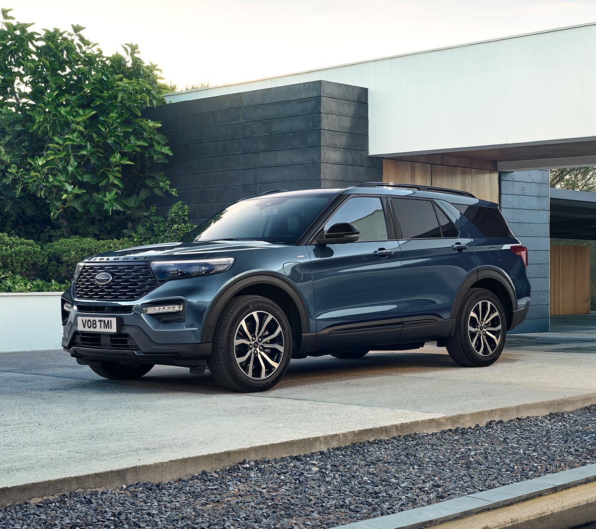 Ford Explorer Plug-in-Hybrid in Blau. Dreiviertel-Frontansicht. Vor einem modernen Gebäude parkend