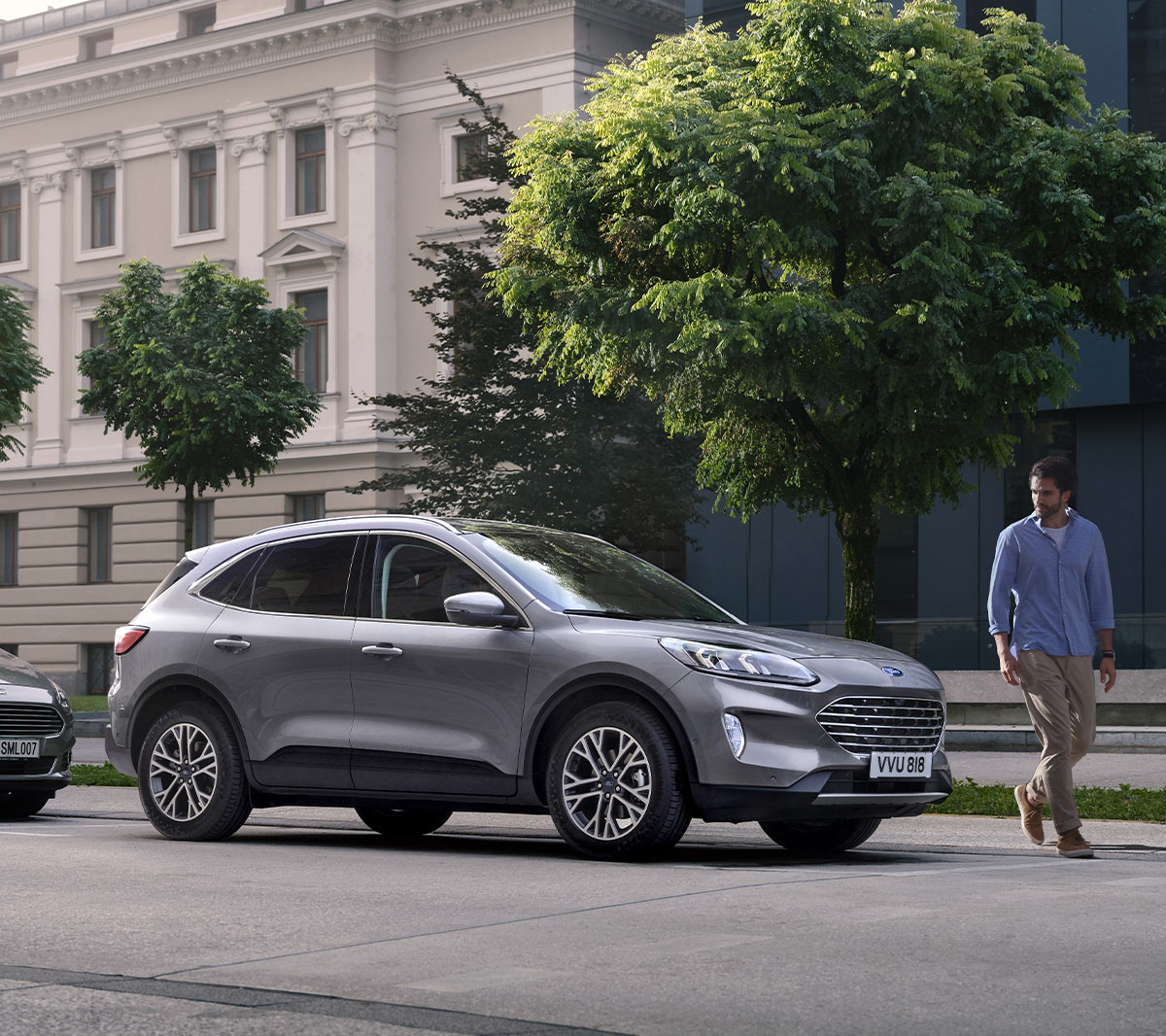 Ford Kuga in Silber. 3/4-Frontansicht, vor einem Altbaugebäude parkend