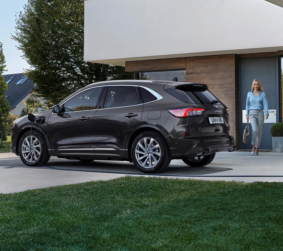 Ford Kuga in Blau. Seitensicht, vor einem modernen Gebäude parkend