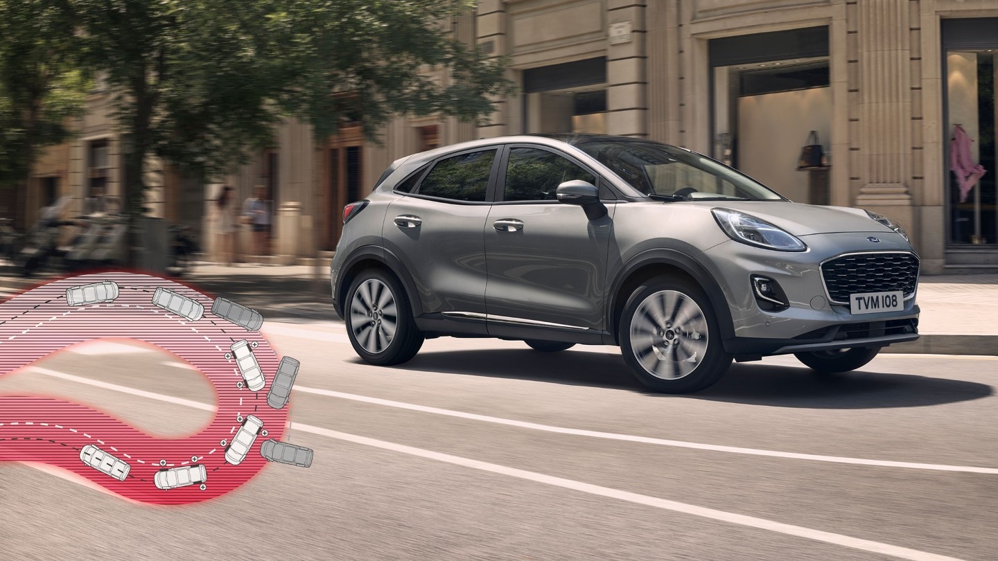 Ford Puma in Grau. Dreiviertelansicht fahrend auf einer Straße mit schematischer Darstellung einer Spitzkehre und Fahrverhalten