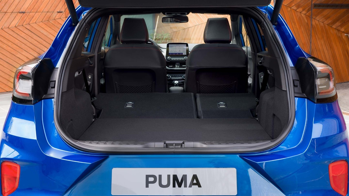 Ford Puma in blau von hinten mit geöffneter Heckklappe und ungeklappten Rücksitzen.