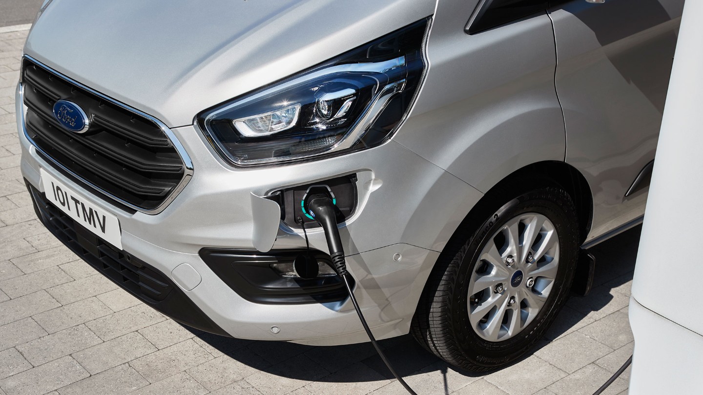 Ford Tourneo Custom Plug-in-Hybrid Silber Assicht Ladeanschuss an Elektro-Tankstelle