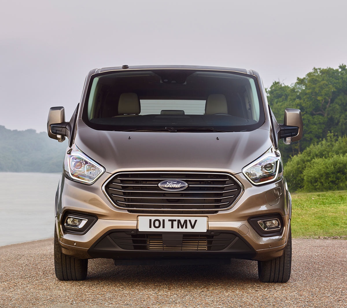 Ford Tourneo Custom Plug-in-Hybrid Silber Frontansicht parkt an Gewässer