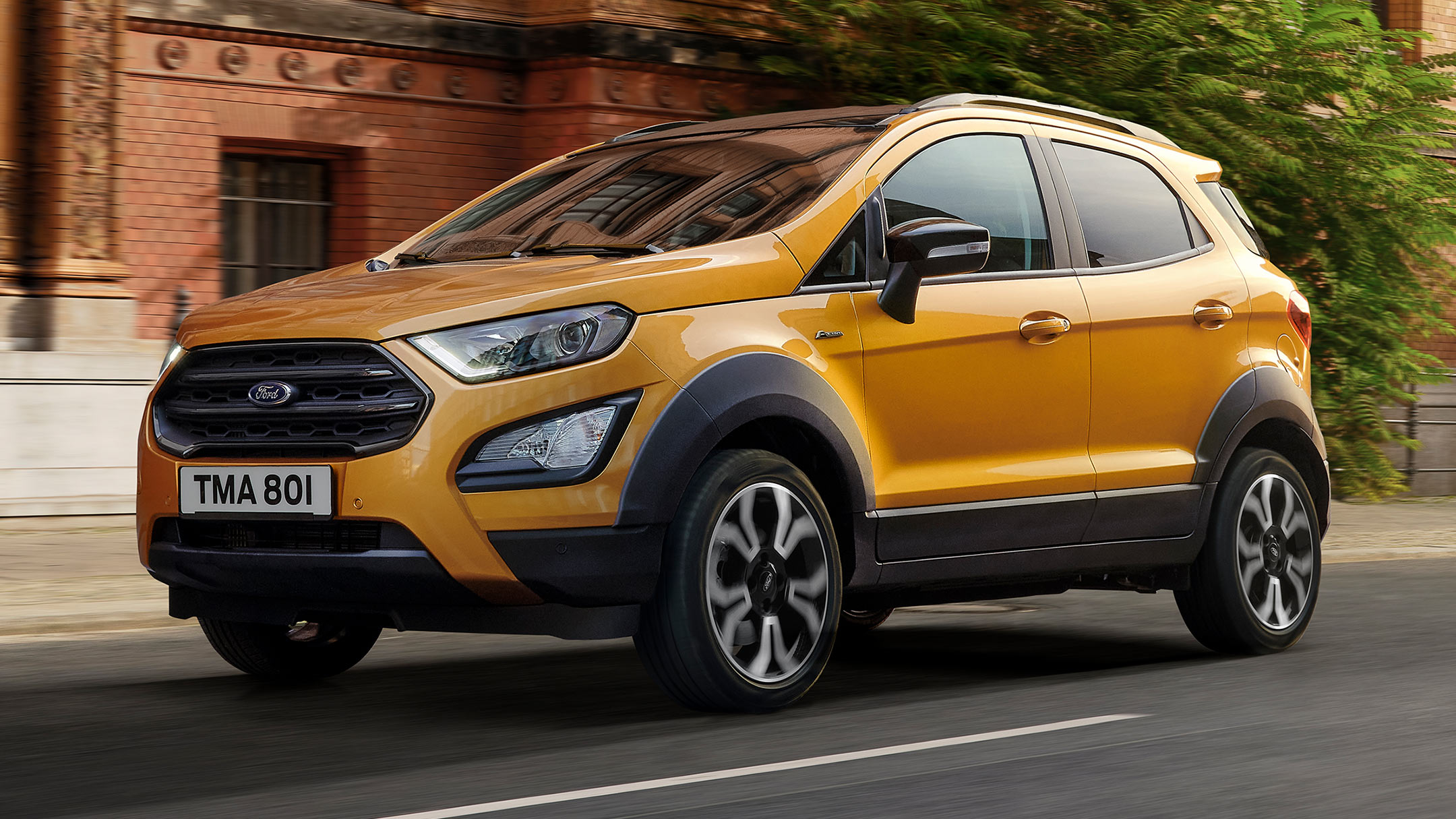 Ford EcoSport Active in Orange. Seitenansicht. Vor einem Gebäude in der Stadt parkend