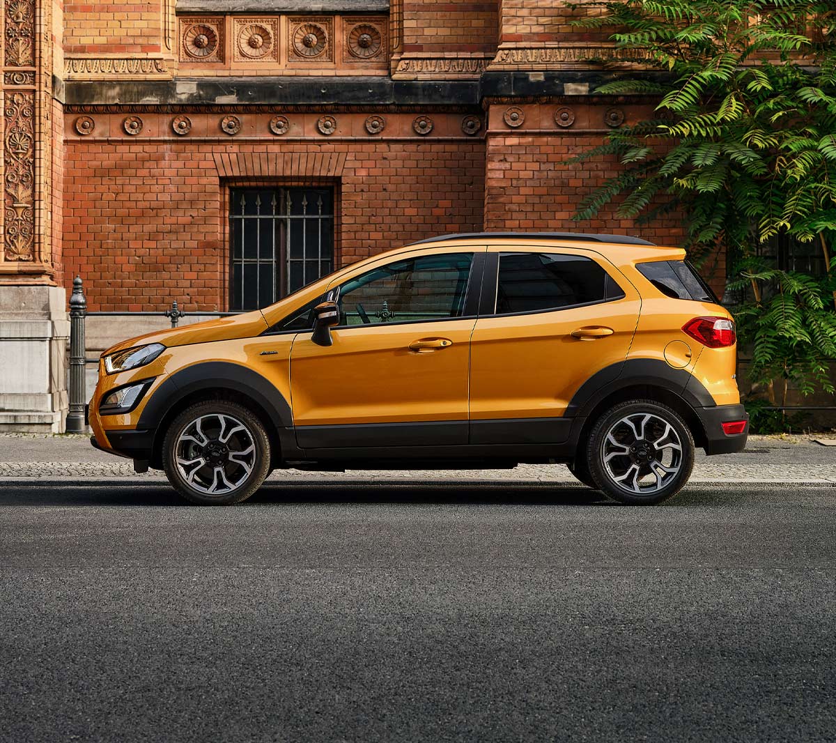 Ford EcoSport Active in Orange. Seitenansicht. Vor einem Gebäude in der Stadt parkend