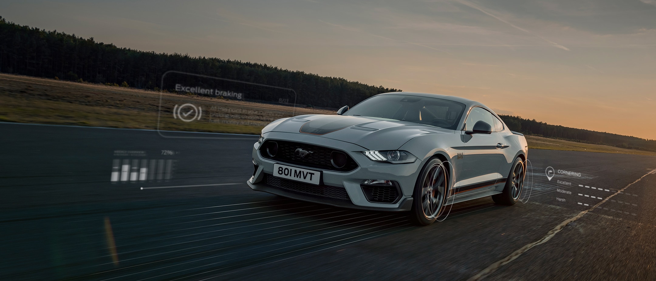 Ford Mustang Mach 1 in Weiß. Dreiviertel-Frontsicht, auf einer Strecke im Sonnenuntergang fahrend