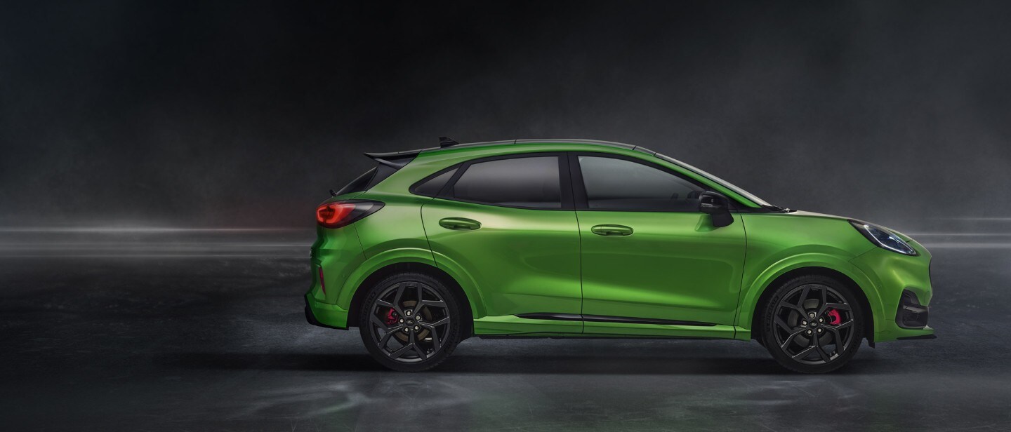 Ford Puma ST in Grün. Dreiviertel-Frontansicht, stehend in einem dunklen Showroom