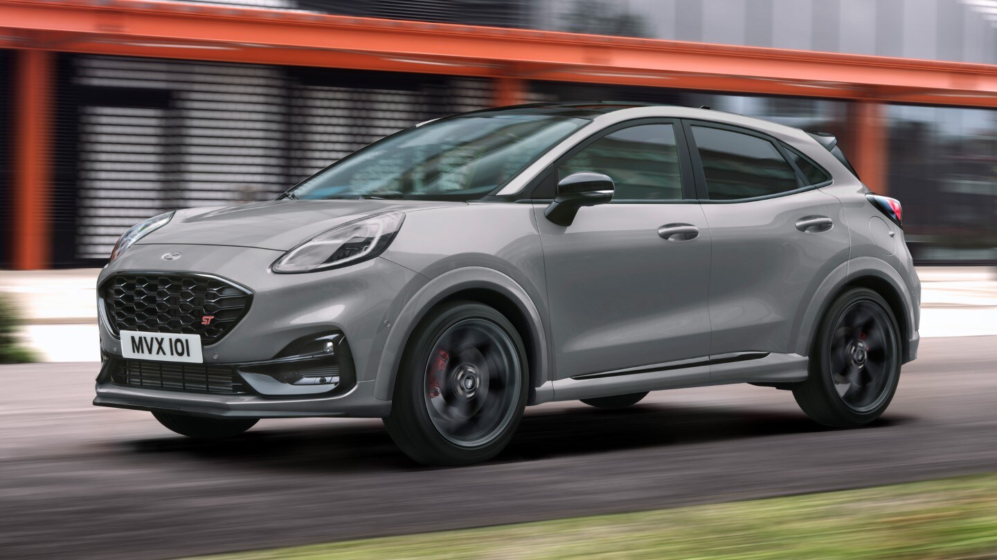 Grauer Ford Puma ST in ¾-Frontansicht auf einer Straße vor modernem Gebäude
