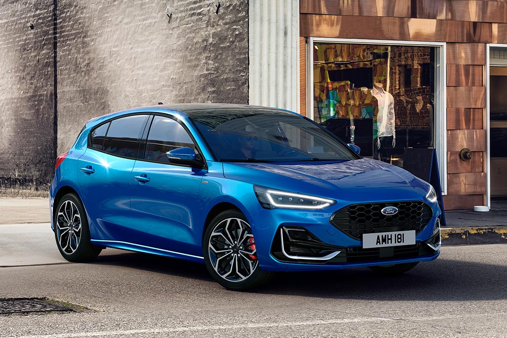 Ein blauer Ford Focus parkt auf einer Straße in der Stadt.