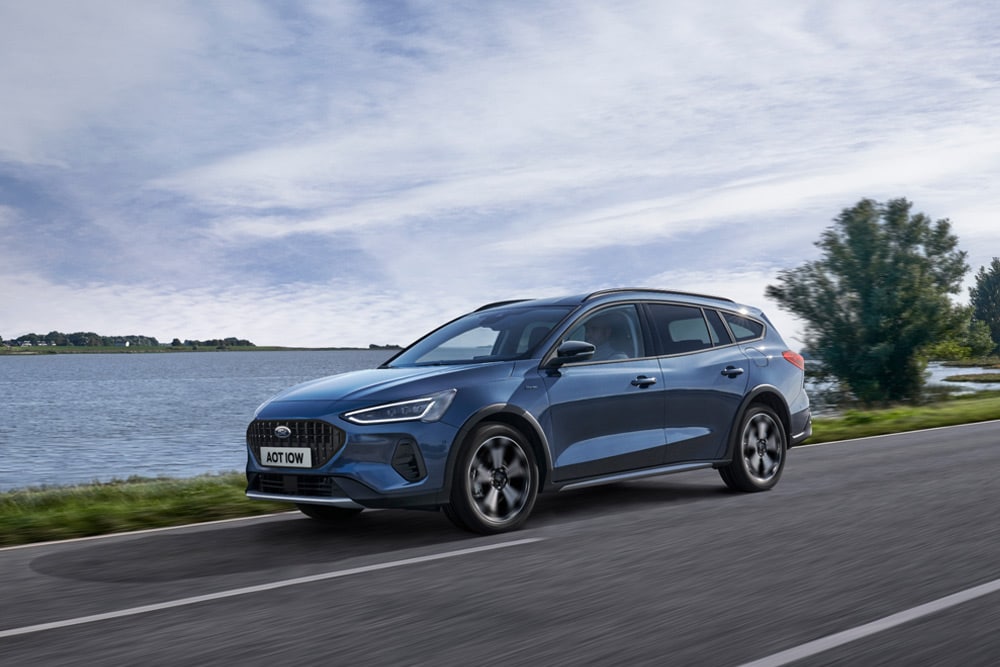 Ein blauer Ford Focus® Turnier, der an einem See vorbeifährt.