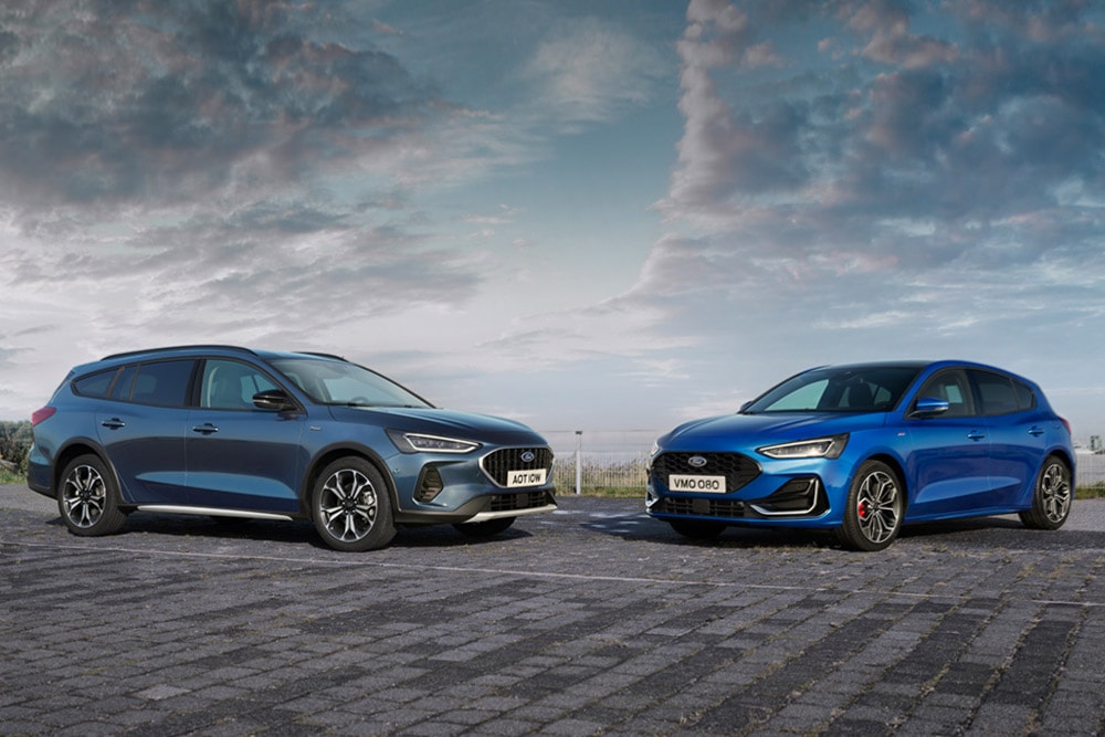 Ein Ford Focus Turnier und ein Ford Focus 5-Türer sind am Straßenrand geparkt.