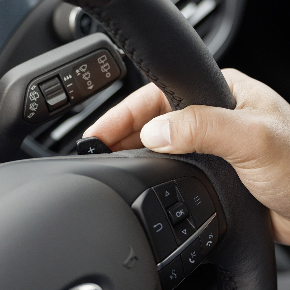 Nahaufnahme einer Hand, die die Schaltwippen des Ford Focus hinter dem Lenkrad bedient.