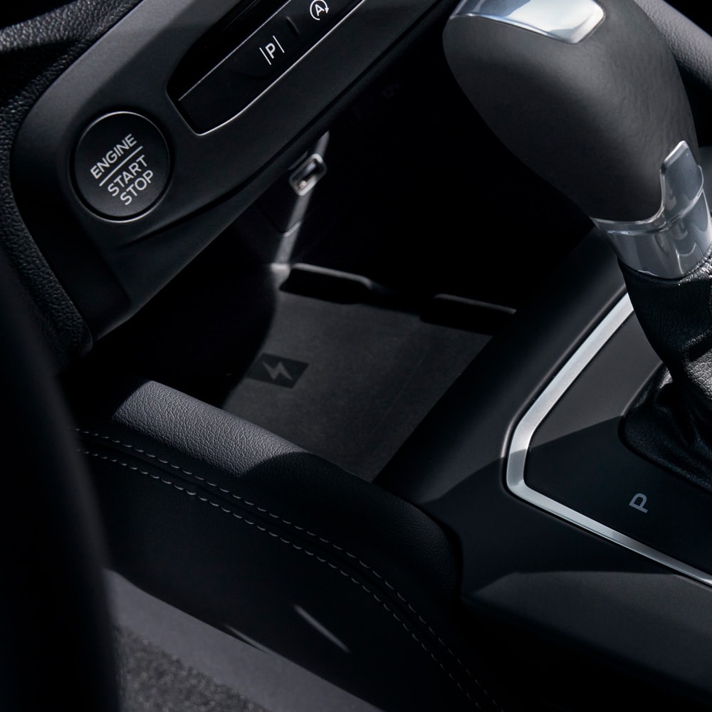 Nahaufnahme des Ford Focus-Innenraums mit kabelloser Ladefunktion für Handys hinter dem Schalthebel.