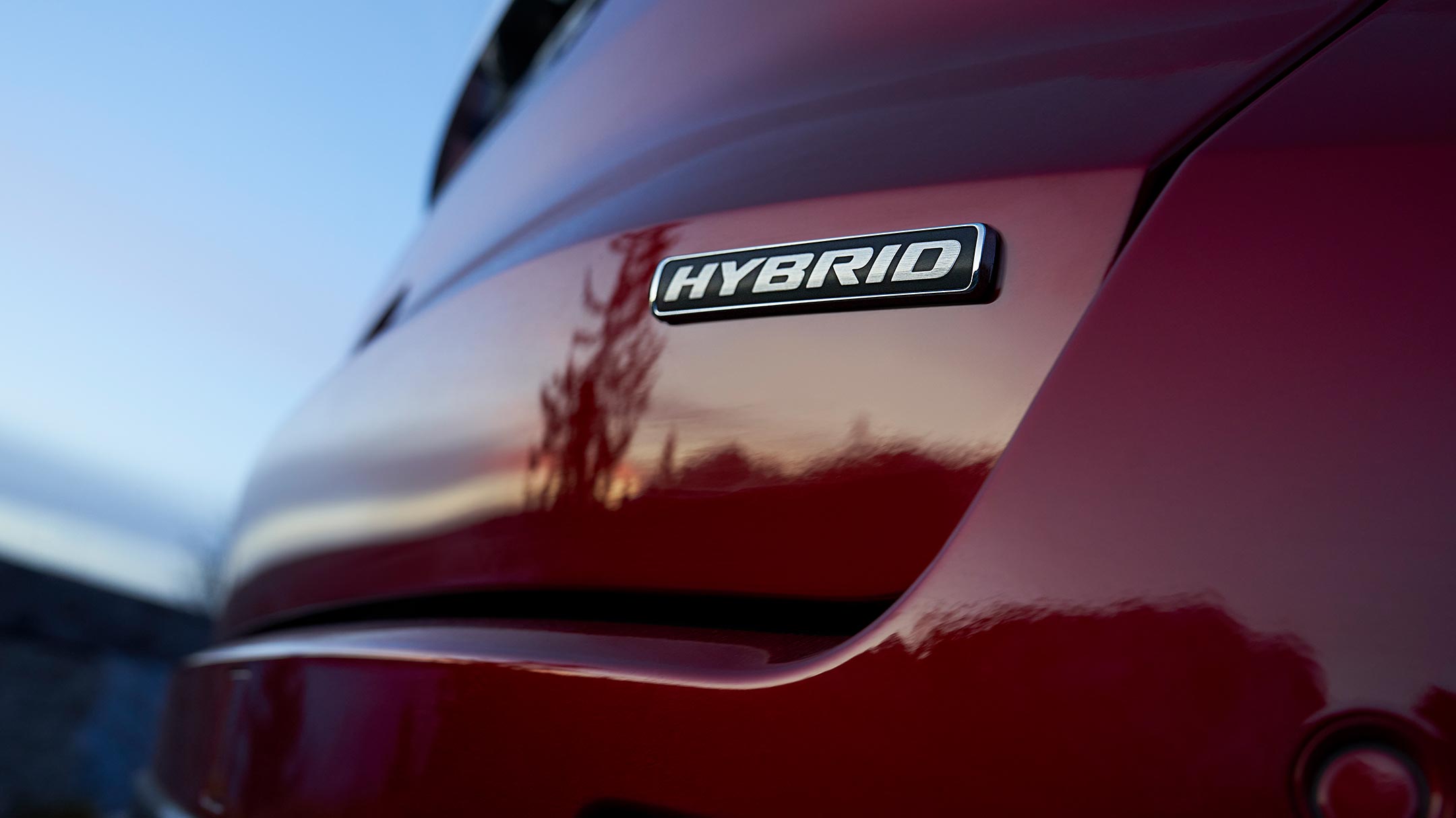 Ford S-MAX Hybrid in Rot. Dreiviertel-Heckansicht, auf einer Brücke fahrend