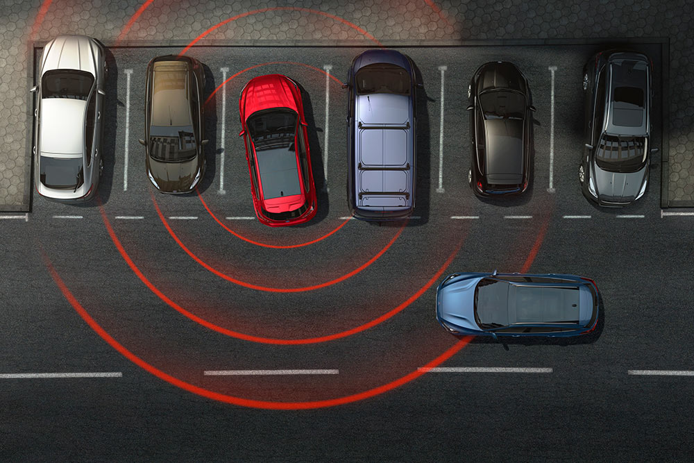 Grafik zeigt ein Ford-Fahrzeug, das rückwärts aus einer Parklücke fährt, mit aktivem Querverkehrswarner.