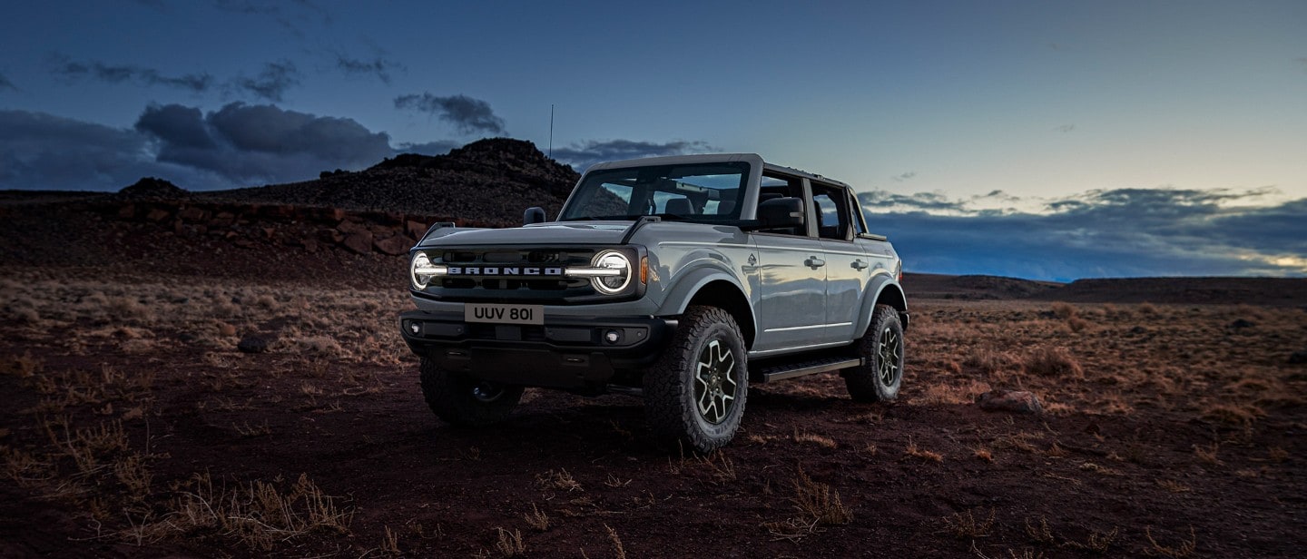 Ford Bronco in Frontansicht bei Dämmerung am Feldrand stehend