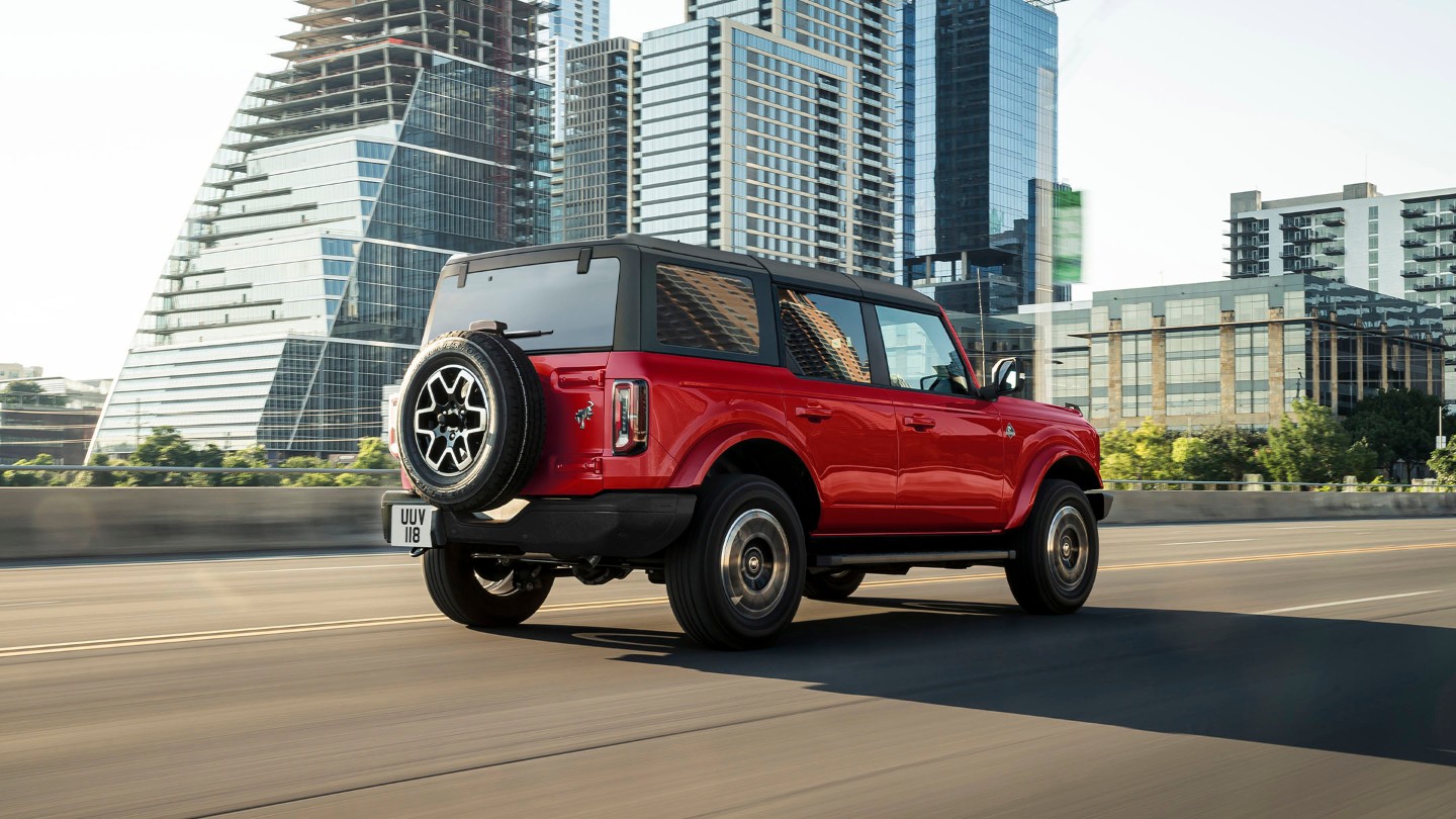 Ford Bronco in Rot. 3/4-Heckansicht. Durch die Stadt fahrend