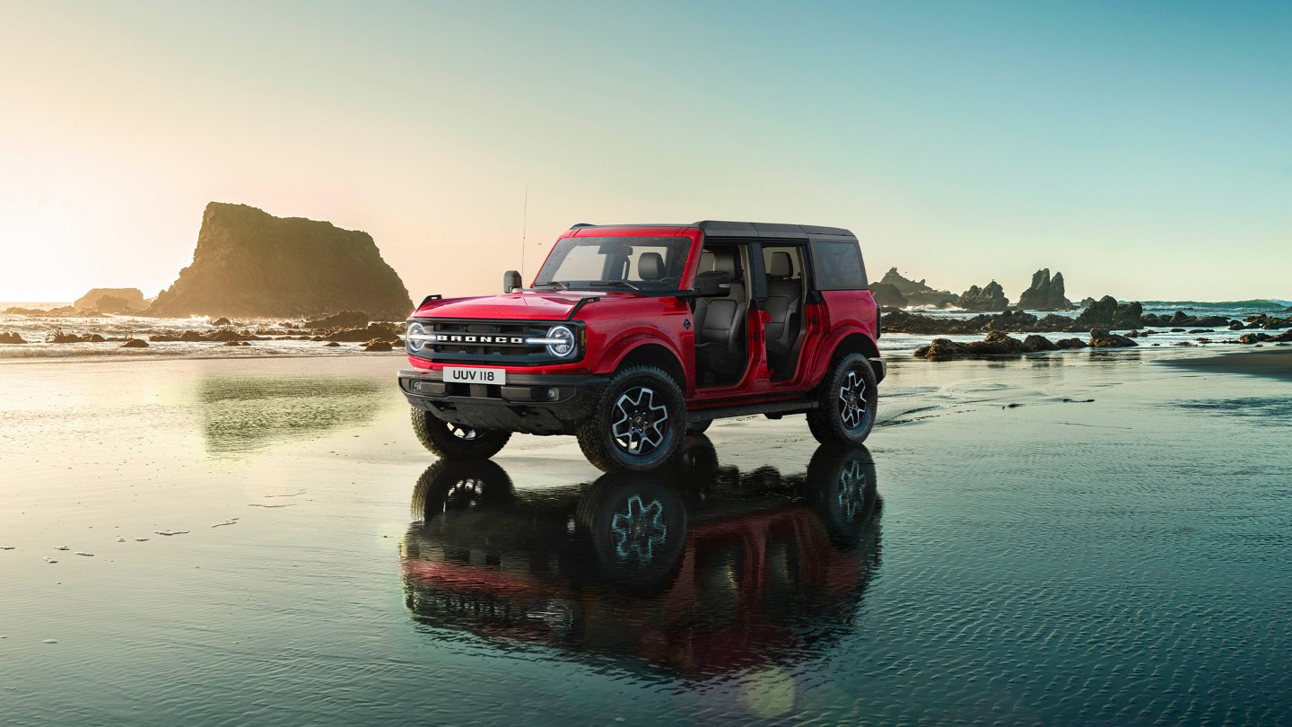 Ford Bronco in Rot, mit abgenommenen Türen auf einer mit Wasser bedeckten Fläche stehend