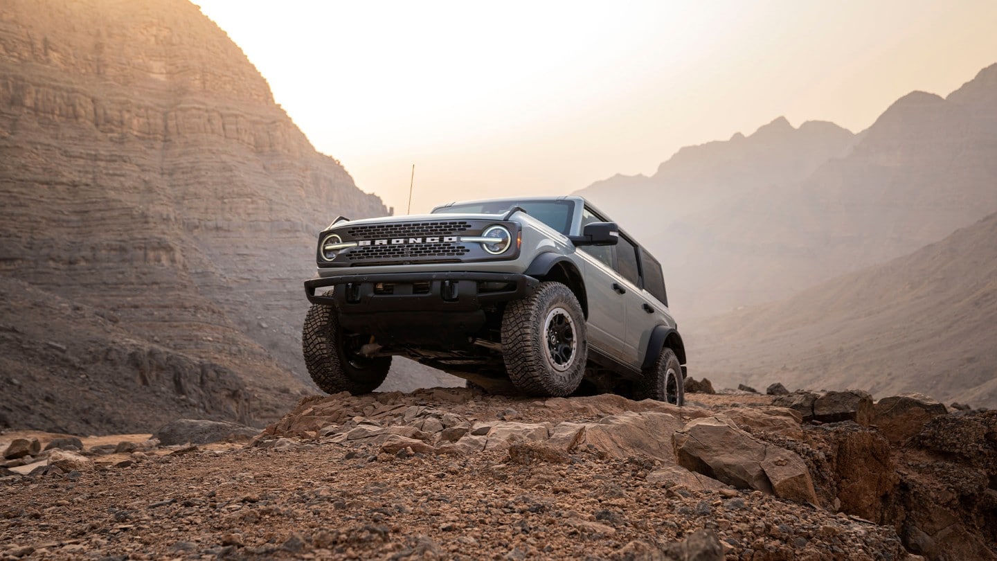 Ford Bronco in Grau. In Frontanischt durch eine Berglandschaft fahrend