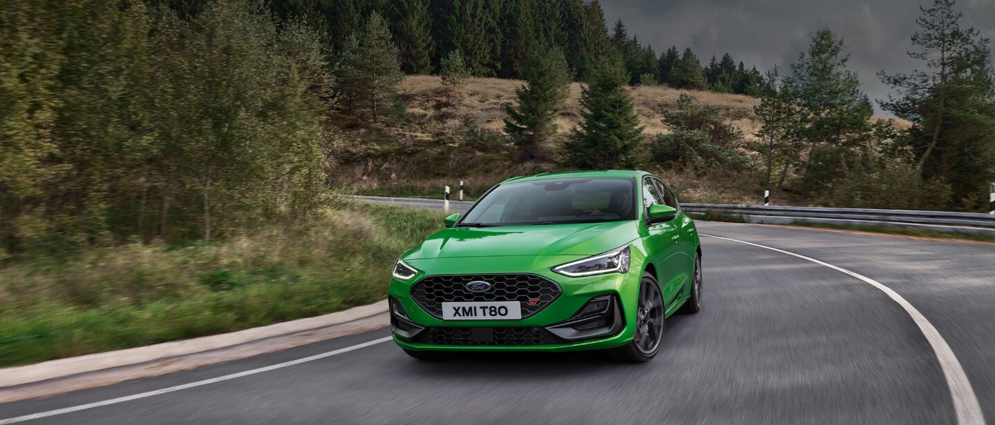 Green Ford Focus ST driving on road