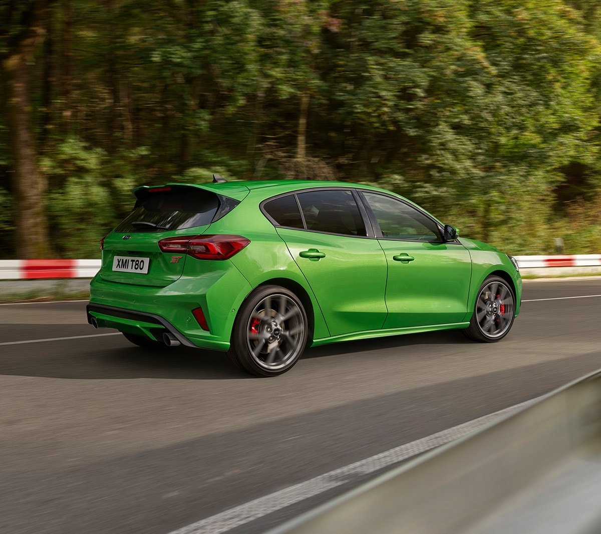 Ford Focus ST in Grün. Dreiviertel-Rückansicht, auf einer Straße fahrend.