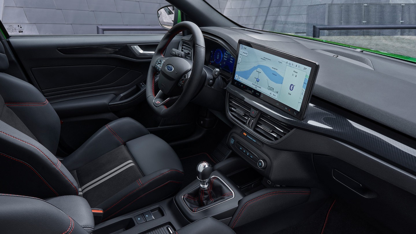 Ford Focus ST Innenraum vorn. Eine Hand bedient den Ford SYNC 4 Bildschirm.