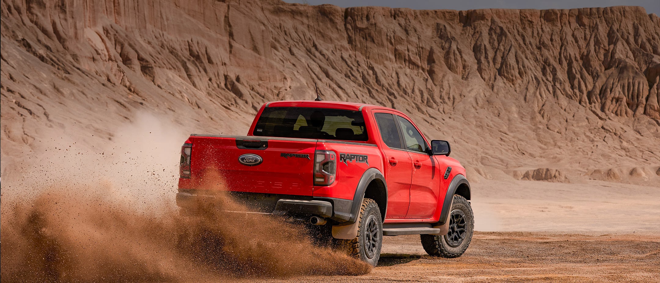 Back 3 quarter view of the Ranger Raptor driving in the desert