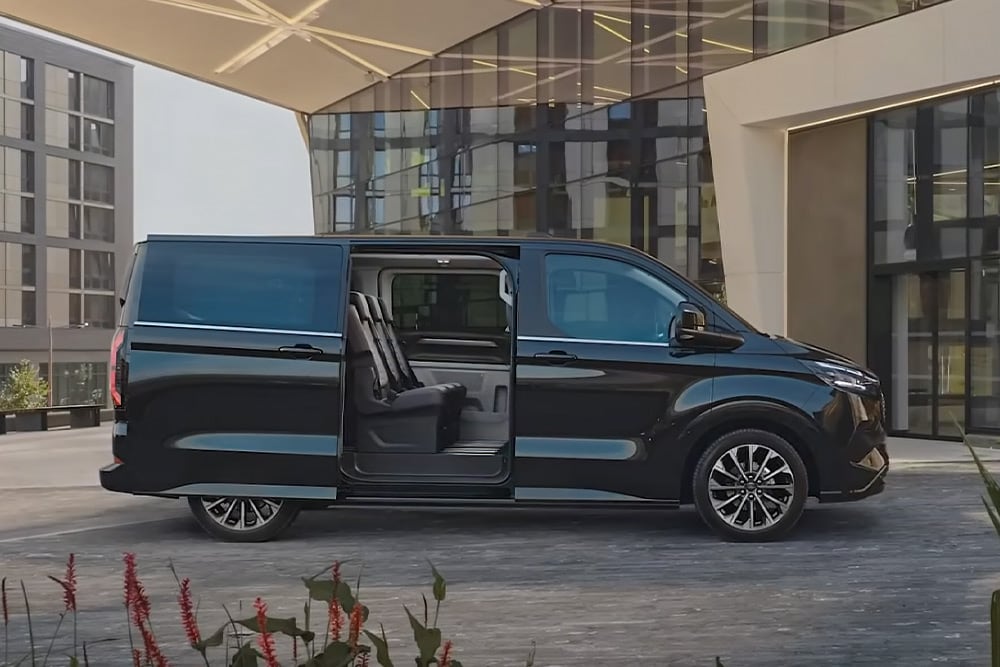 Schwarzer Ford E-Tourneo Custom mit geoÃàffneter Schiebetuer, Innenraum sichtbar