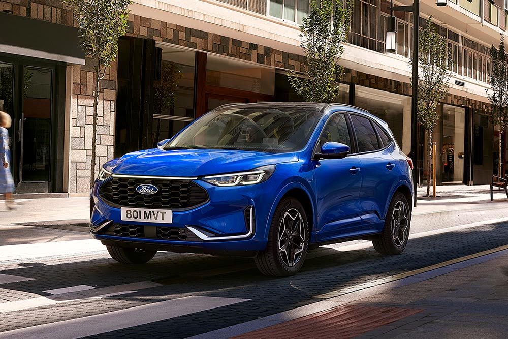 Ein Ford Kuga ST Line in der Farbe Desert Island Blue, geparkt in einem Wohngebiet. 