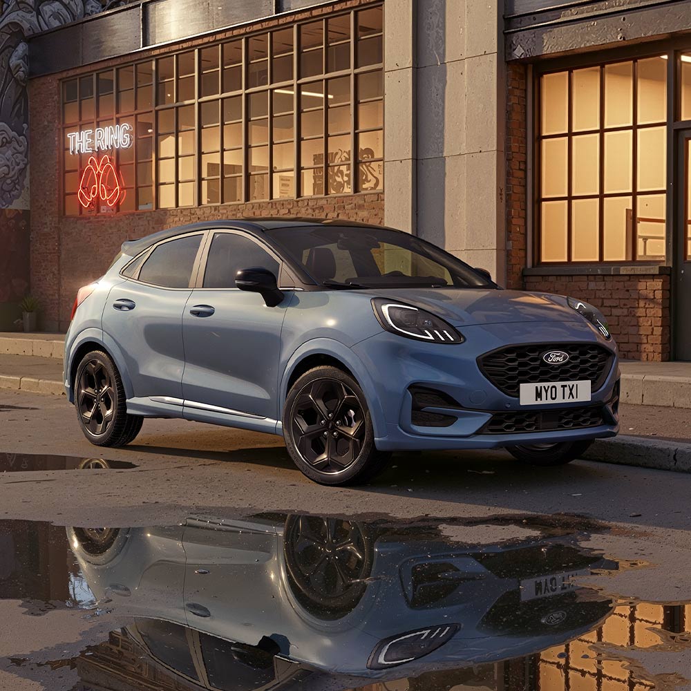 Ein Ford Puma in der Sonderfarbe Vapour Blue , der auf einer schwach beleuchteten Stadtstraße geparkt ist.