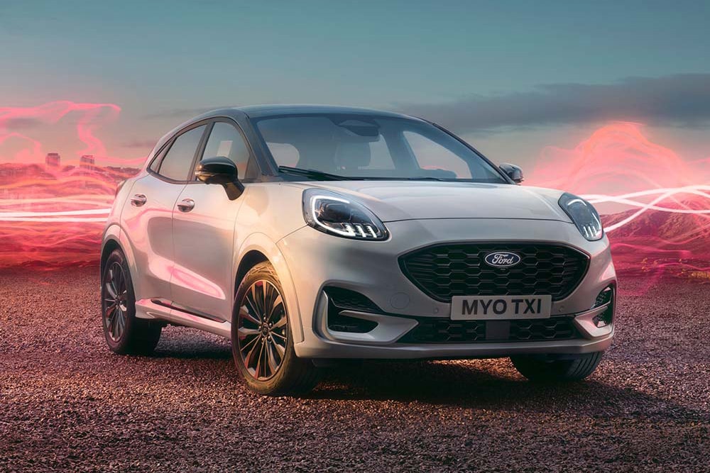 Ford Puma Sound Edition in weiß, parkend mit roter Schallwellengrafik im Hintergrund.
