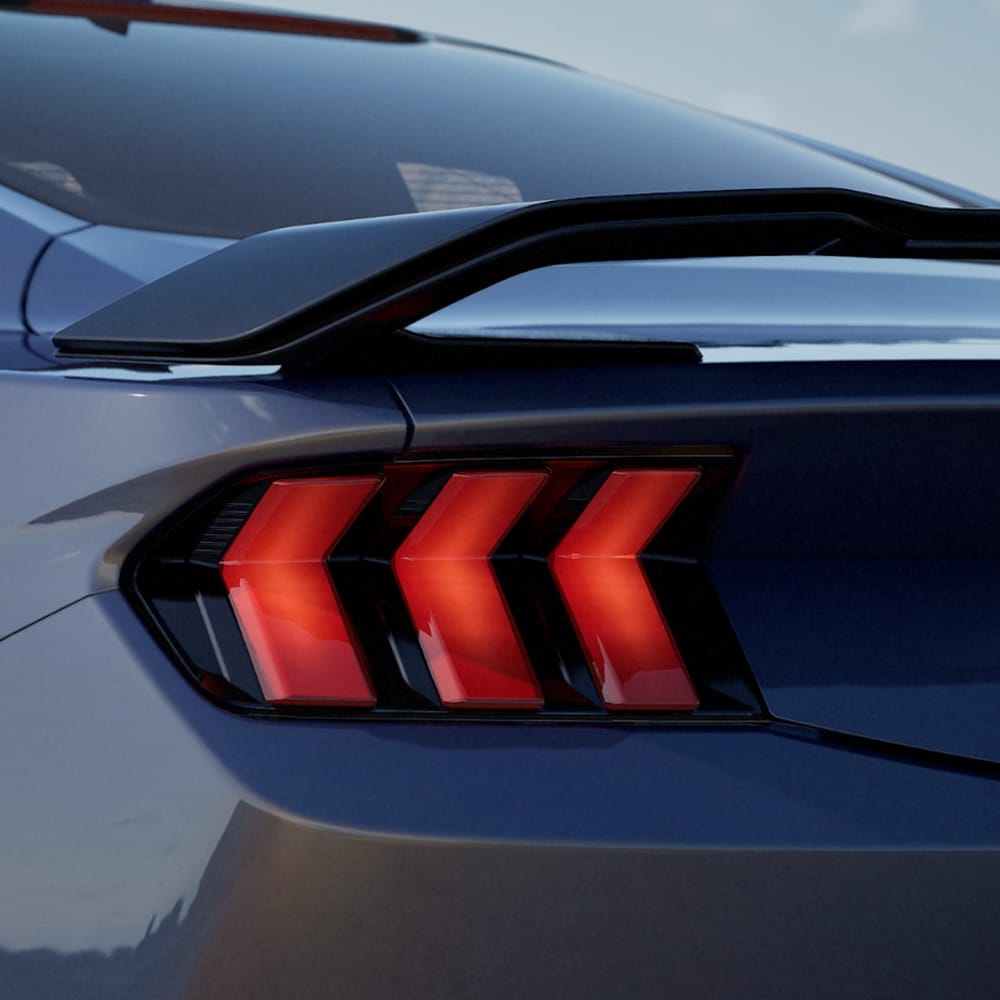 Eine Nahaufnahme der hinteren Rückleuchten eines Ford Mustang Dark Horse Fastback  in der Farbe blau.