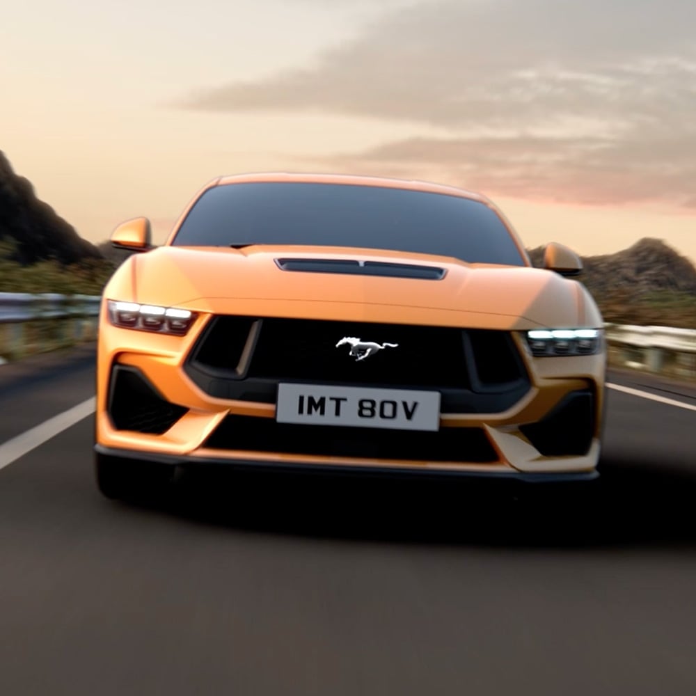 Ein grauer Ford Mustang, der um eine Kurve fährt