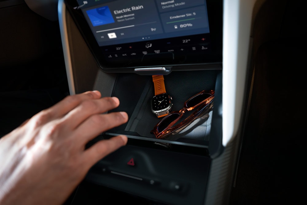 Eine Hand greift nach dem Fach „My Private Locker“ im Ford Capri®. Darin sind eine Uhr und eine Sonnenbrille zu sehen.