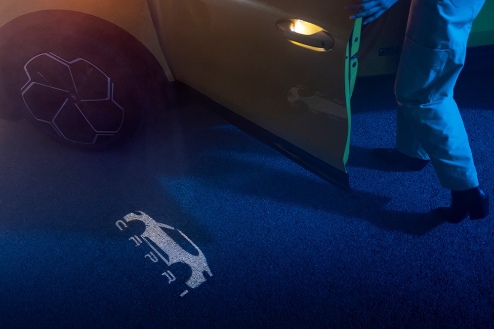 Die Projektionslichter des neuen vollelektrischen Ford Capri® bilden das Capri-Logo auf den Boden ab.