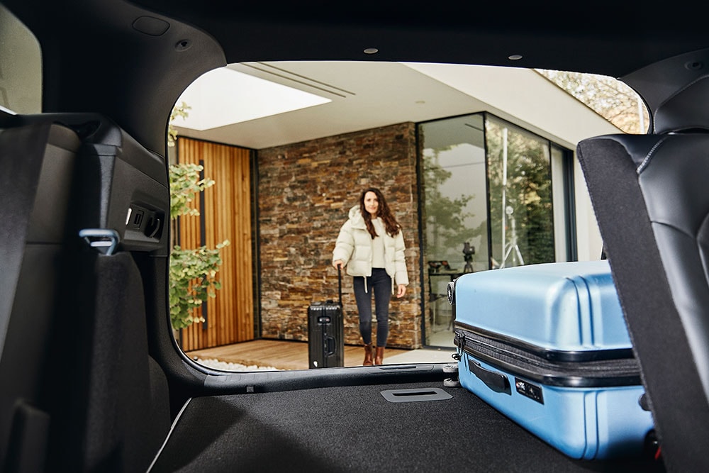 The rear luggage space of the Ford Explorer, taken from the inside of the car, including a blue suitcase. 