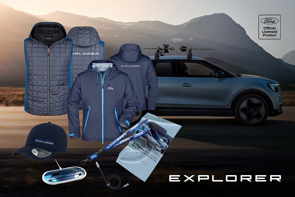 Ford Explorer Lifestyle-Kollektion mit Jacken, Kappen und Zubehör vor einem Ford Explorer in den Bergen.