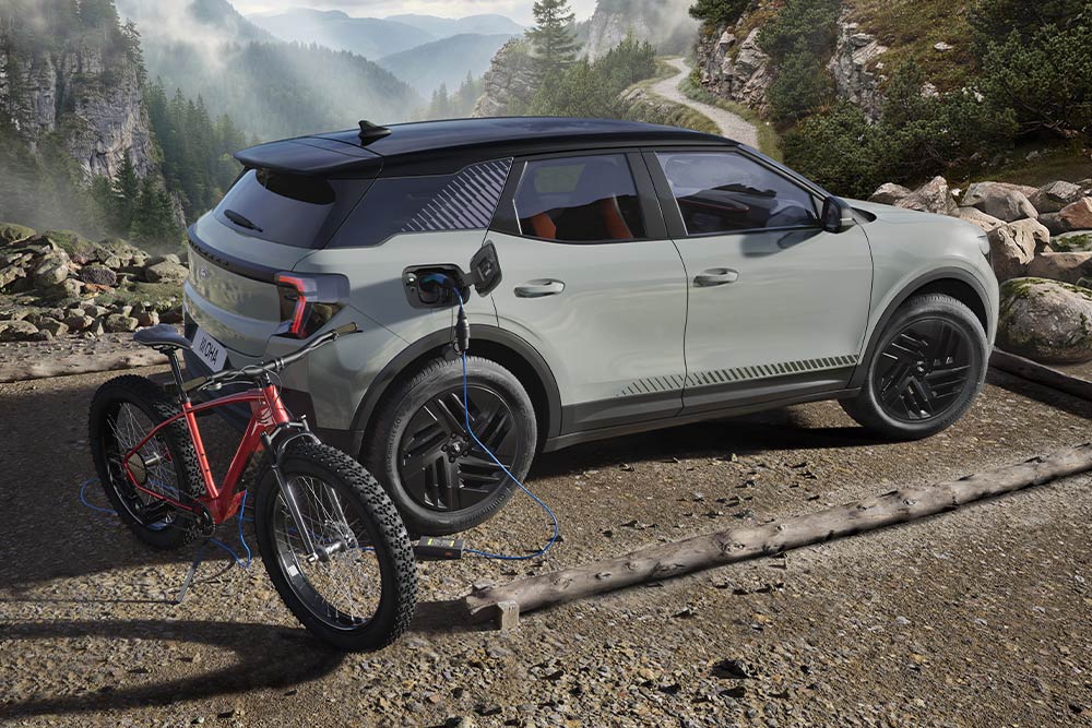 Ein E-Bike, das an einem Ford Explorer® aufgeladen wird, mit einer Berglandschaft im Hintergrund.