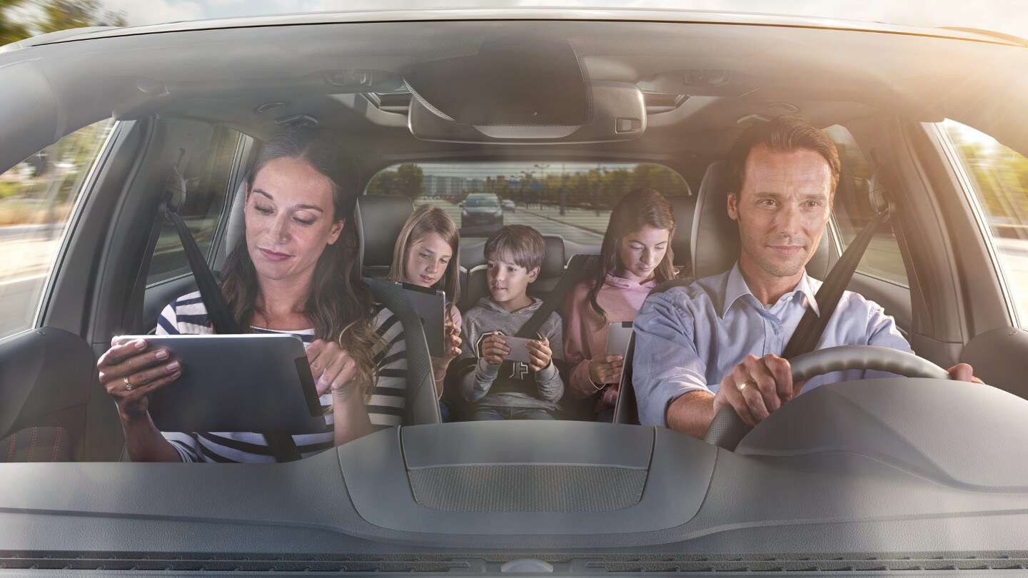 Ford S-MAX Hybrid. Frontansicht, Blick durch Windschutzscheibe auf Familie im Auto sitzend
