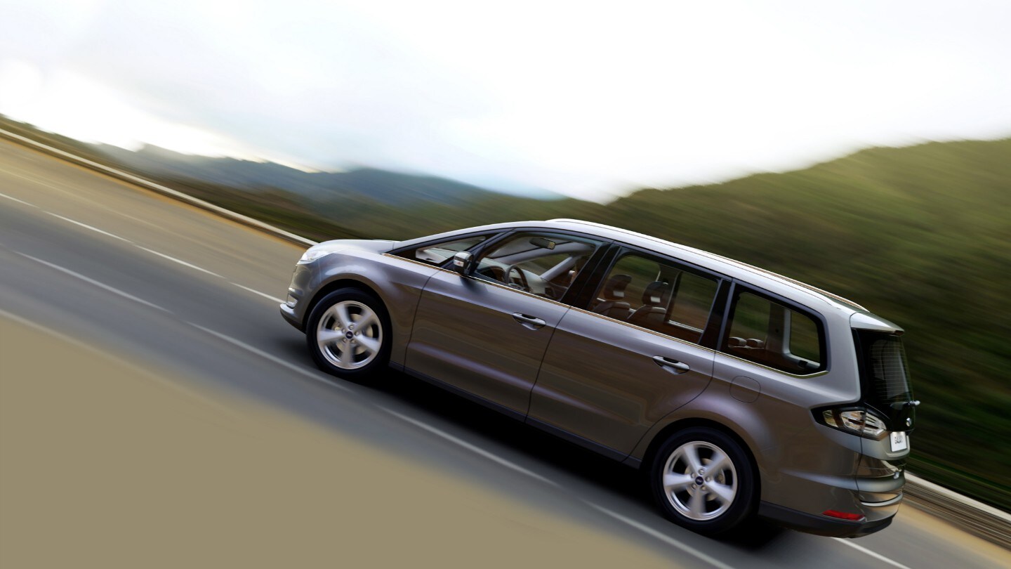 Ford Galaxy Hybrid Grau Seitenschuss fahrend Berganfahrassistent