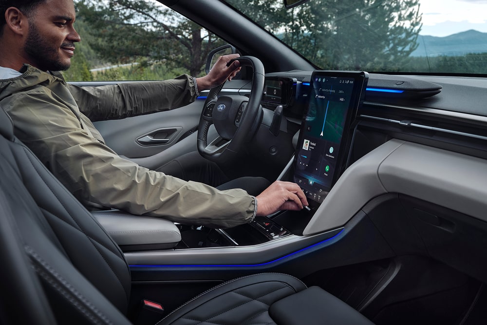 Fahrer nutzt das Touchscreen-Infotainmentsystem im Familien-SUV Ford Explorer.