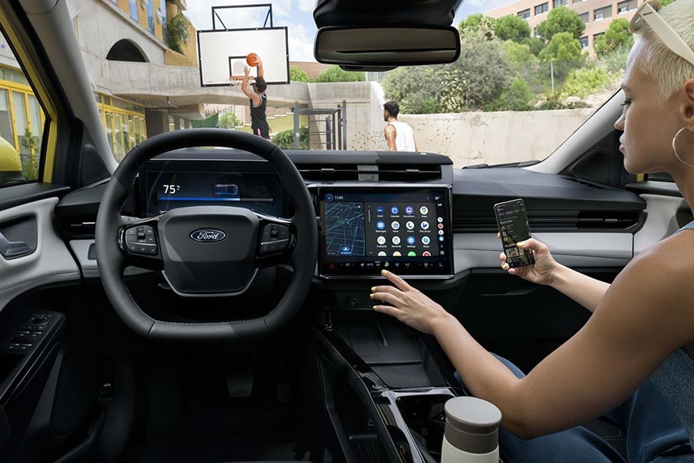 Innenraum des Ford Puma Gen-E Kleinwagens mit Touchscreen-Bedienelementen.