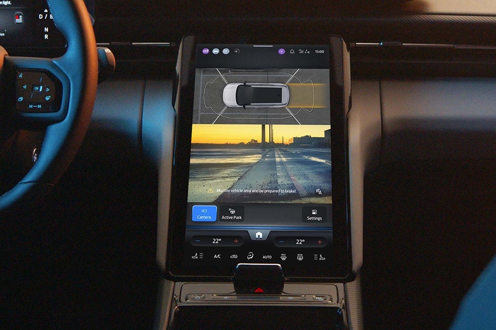 Nahaufnahme eines digitalen Touchscreens eines Ford SUV, auf dem das Active Park Assist-System in Betrieb zu sehen ist.