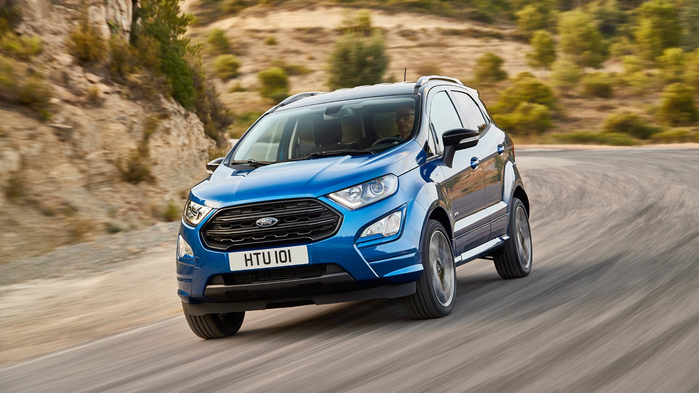 Ford EcoSport in Blau in der 3/4 Frontansicht fährt auf Landstraße durch eine Kurve