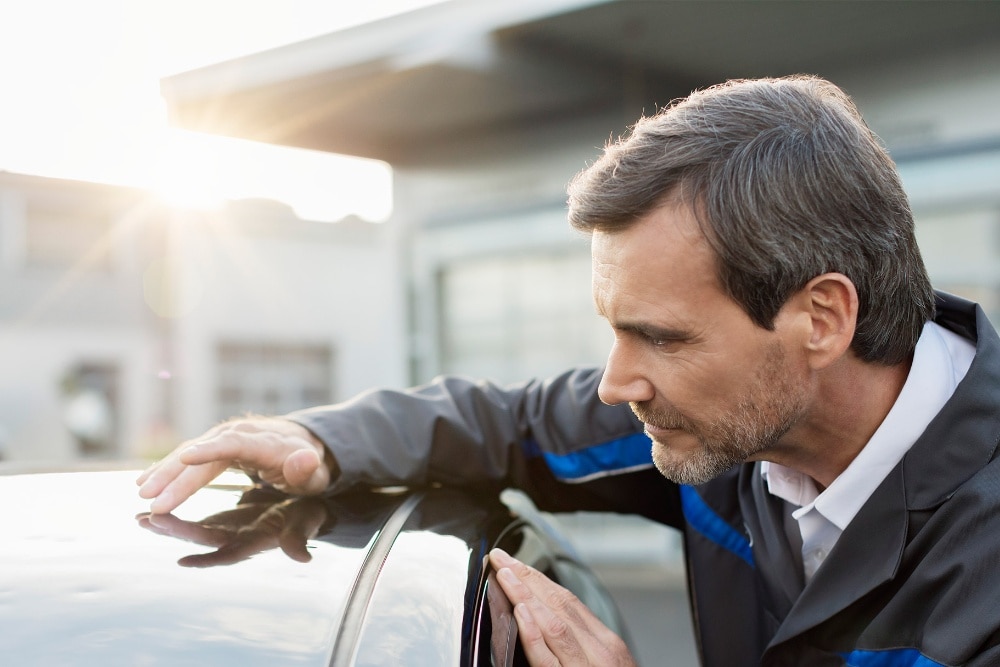 Ford-Servicetechniker, der ein Fahrzeugdach inspizíert
