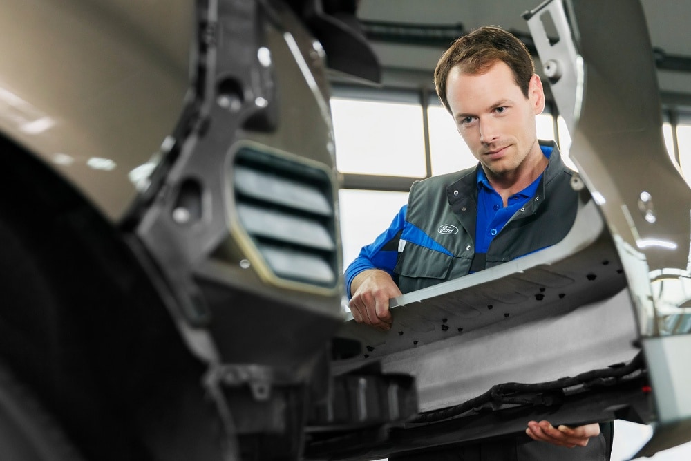  Ford-Servicetechniker der den vorderen Stoßfänger austauscht